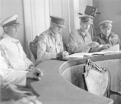 [Thumb - The British Commander signs the Instrument of Surrender. Left to right are Capt Legge Naval chief - Brig Moffat Force Commd- Col Baird 2 IC- Col Tsigante Commd Greek Sacred Re.jpg]